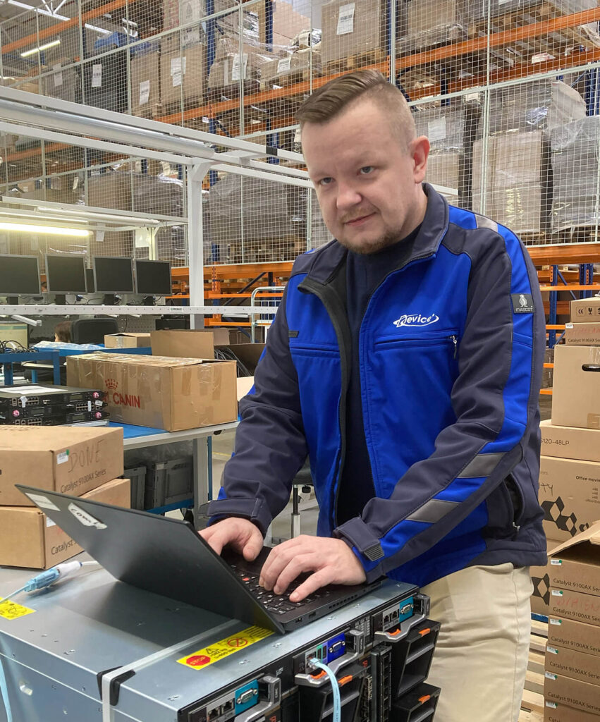 Device Europe technician testing a laptop on IT hardware in a warehouse
