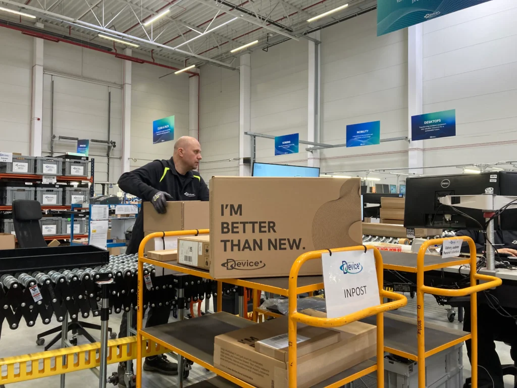 Device Europe employee processing a cardboard return box for IT equipment in the company’s logistics and refurbishment facility.